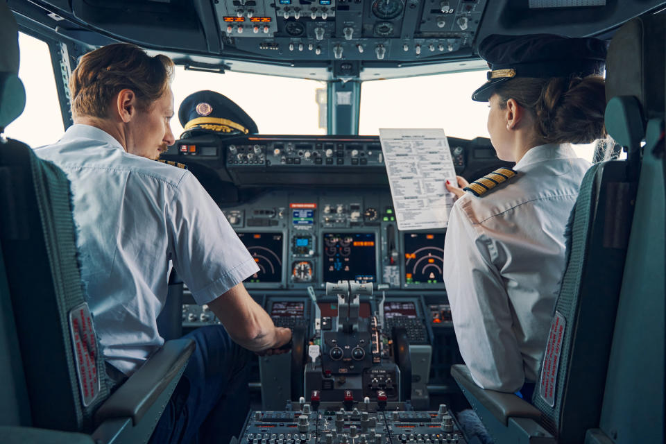 Back view of a co-pilot with a captain in the cockpit