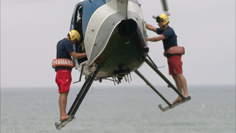 In this undated image released by The Weather Channel, two lifeguards prepare to make a rescue in a scene from ""Lifeguard!," about beach rescuers in southern California. The series airs Thursdays at 9 p.m. on The Weather Channel. The Weather Channel is in the midst of a transformation with original programming about Arctic pilots, steel workers, wind turbine and power line repairers and Coast Guard rescuers in both icy and tropical climates. (AP Photo/The Weather Channel)