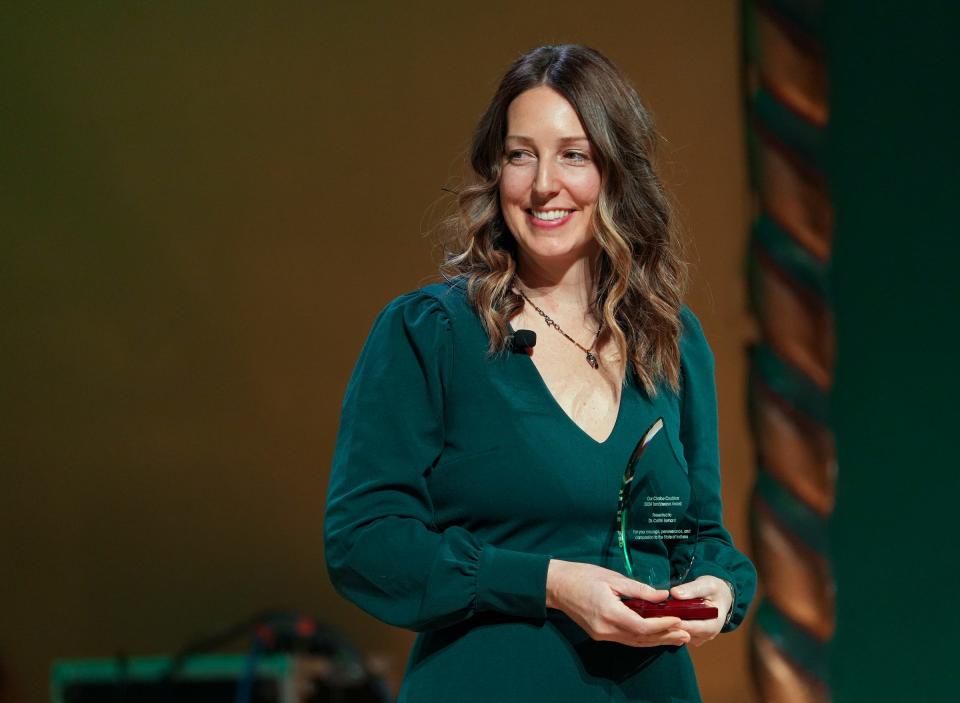 Dr. Caitlin Bernard stands on stage as she receives the Our Choice Coalition Torchbearer Award on Monday, Jan. 22, 2024, at the Indiana Roof Ballroom in Indianapolis.