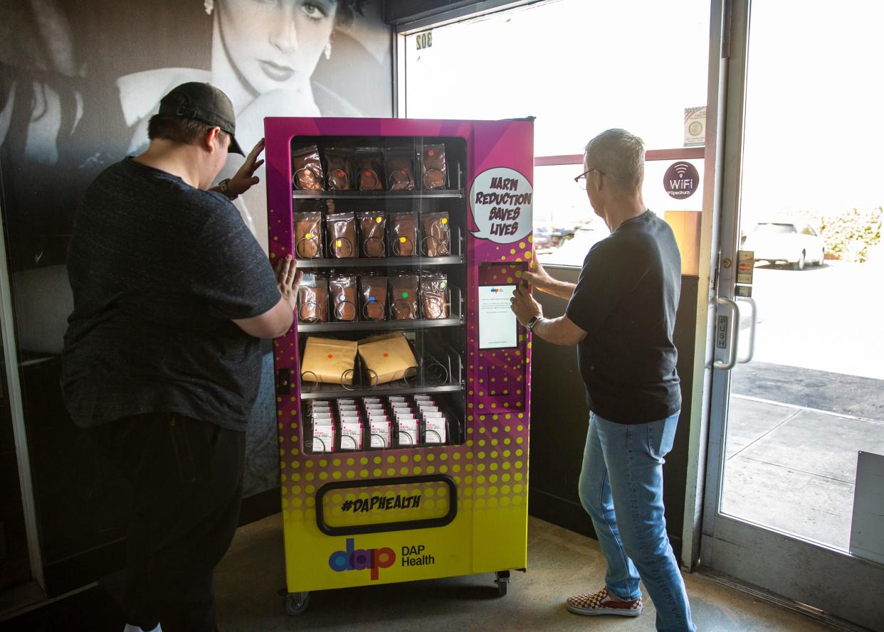 Workers help position a harm reduction vending machine at Hunter's in Palm Springs, Calif., Thursday, Sept. 14, 2023. DAP Health installed the vending machine to provide items such as Narcan, cookers, fentanyl test strips, HIV test kits and more for free for anyone who may have a need.