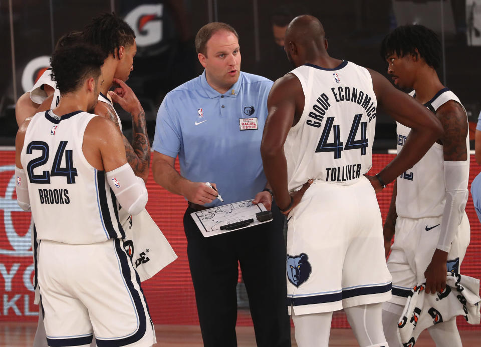 Memphis Grizzlies head coach Taylor Jenkins, center, reviews a play with his players during a timeout against the Oklahoma City Thunder in the first half of an NBA basketball game Friday, Aug. 7, 2020, in Lake Buena Vista, Fla. (Kim Klement/Pool Photo via AP)