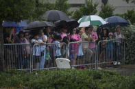 Fans wait in the rain in hopes of catching a glimpse of Lionel Messi leaving after a training session for the Inter Miami MLS soccer team, Tuesday, July 18, 2023, in Fort Lauderdale, Fla. (AP Photo/Rebecca Blackwell)