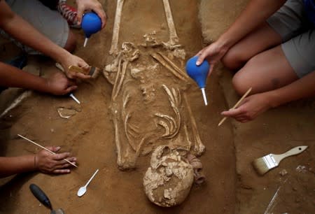 FILE PHOTO: American archaeology students unearth a skeleton during excavation works at the first-ever Philistine cemetery at Ashkelon National Park