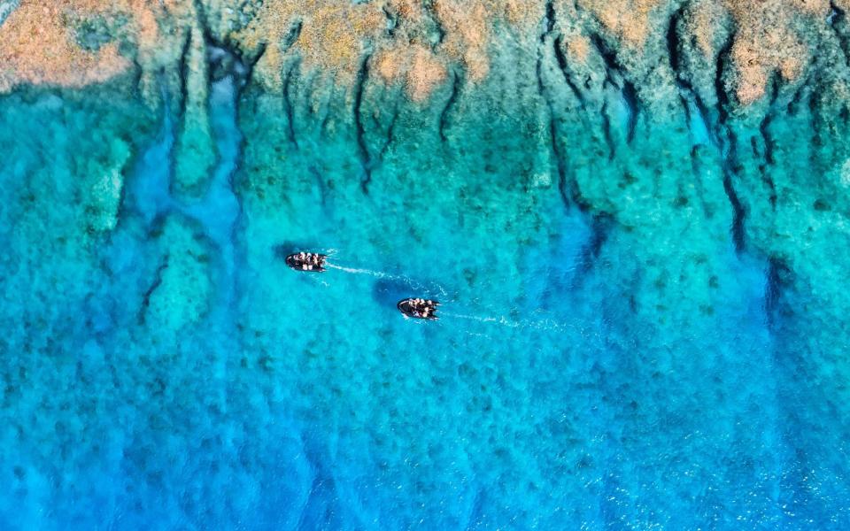 aerial view of two zodiac boats in blue water