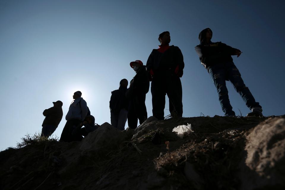 Migrants stand near the U.S.-Mexico border in Ciudad Juarez, Mexico, Dec. 19, 2022.