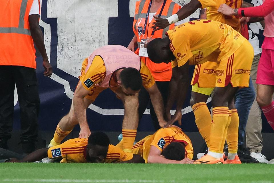 Rodez'  El centrocampista francés Lucas Buades (centro) yace en el suelo después de ser alcanzado por un proyectil durante el partido de fútbol de la L2 francesa entre el FC Girondins de Bordeaux y el Rodez AF en el estadio Matmut Atlantique de Burdeos, el 2 de junio de 2023. (Foto de THIBAUD MORITZ / AFP) (Foto de THIBAUD MORITZ/AFP a través de Getty Images)