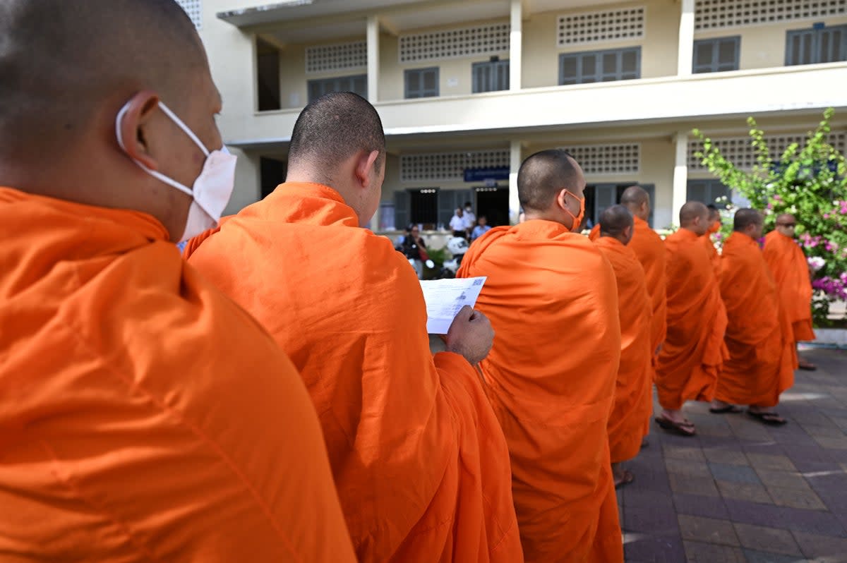 Buddhist monks line up to cast their votes at a polling station in Phnom Penh on 23 July, 2023 during the general elections (AFP via Getty Images)