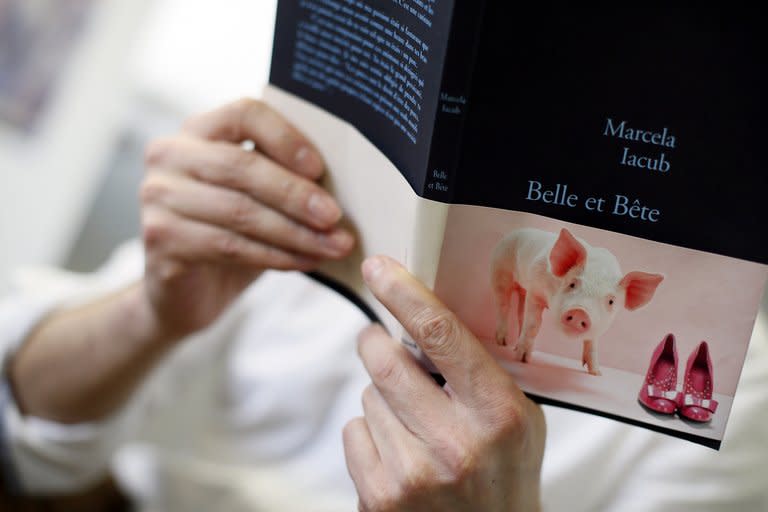 A man holds a copy of "Belle et bete" (a play of word which can be translated as "Beauty and the Beast" or "Beautiful and Stupid"), a book written by French lawyer Marcela Iacub detailing her relationship with disgraced former IMF boss Dominique Strauss-Kahn, in Paris on February 21, 2013