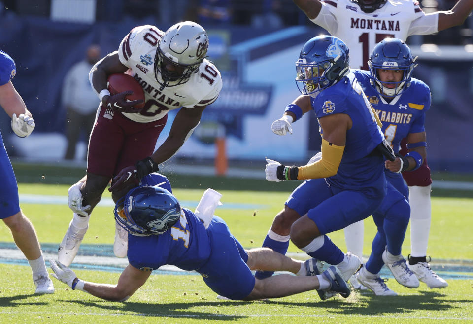 Montana running back Eli Gillman (10) is tackled by South Dakota State safety Colby Huerter (14) at the FCS Championship NCAA college football game Sunday, Jan. 7, 2024, in Frisco, Texas. (AP Photo/Richard W. Rodriguez)