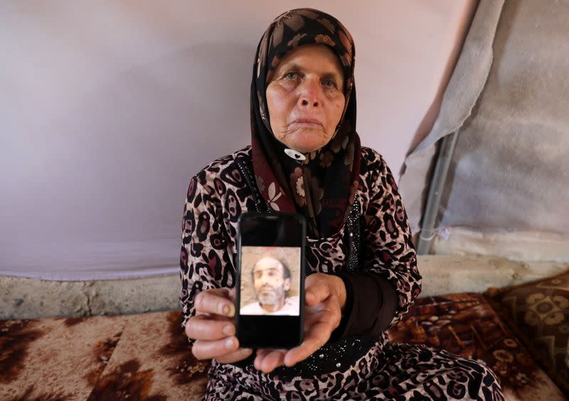 Fouziya al-Ghajar, 75, displays a picture of her deceased brother in Idlib