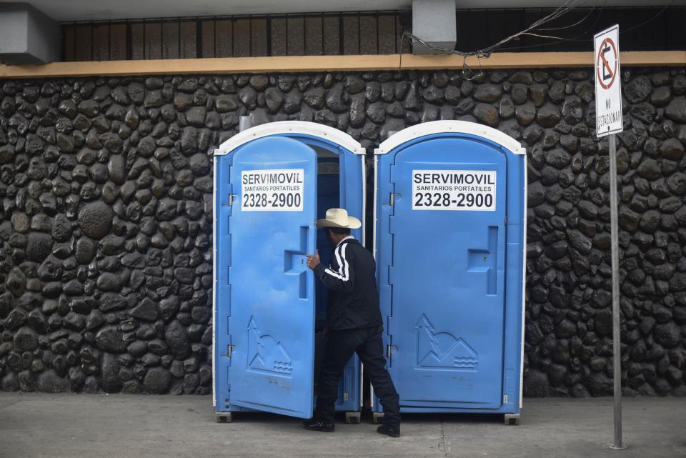 <p>A man enters a <em>toilet movil</em> in Guatemala City, Guatemala. (Photo: Ohan Ordonez/AFP/Getty Images) </p>