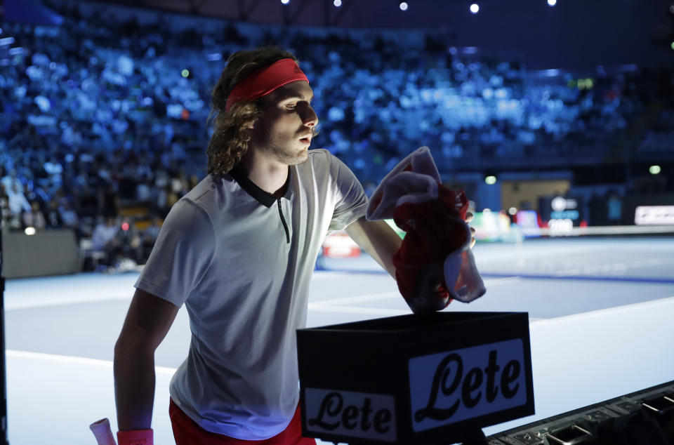 Stefanos Tsitsipas of Greece, handles his towel as he plays against Alex De Minaur of Australia, during the ATP Next Gen tennis tournament final, at the Rho fair, near Milan, Italy, Saturday, Nov. 10, 2018. During the event, featuring many of the innovations that debuted last year, players are instructed to use a towel rack at the back of the court to remove the onus on ball kids to handle towels. (AP Photo/Luca Bruno)