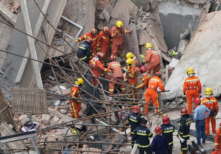 Firefighters work at the site where a building collapsed, in Shanghai, China May 16, 2019. REUTERS/Aly Song