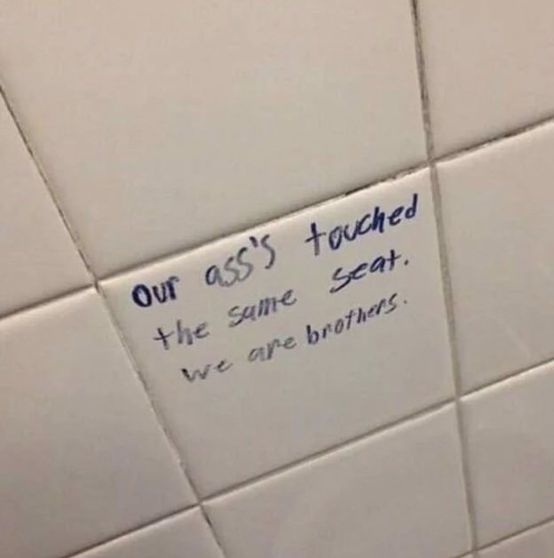 Text on a bathroom wall reads, "Our ass's touched the same seat. We are brothers."