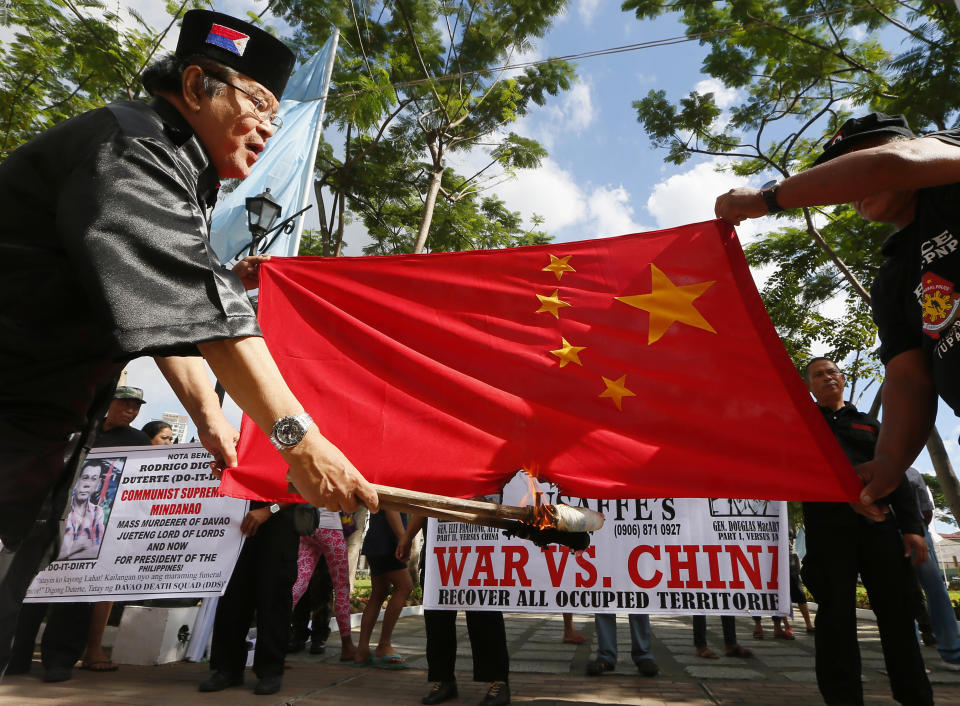 Philippine presidential candidate Elly Pamatong burns a Chinese flag in Manila, Dec. 4, 2015, to denounce China's island-building at the disputed Spratly Islands in the South China Sea. Global trade already was depressed by the 2-year-old tariff war between China and the U.S., the world’s two biggest economies. Now, their rancor is spreading to include Hong Kong, Chinese Muslims, spying accusations and control of the South China Sea. (AP Photo/Bullit Marquez, File)