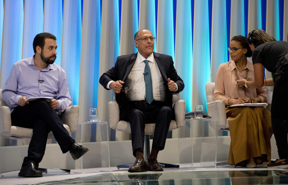 Guilherme Boulos, presidential candidate of the Socialism and Liberty Party, left, Geraldo Alckmin, presidential candidate of the Social Democratic Party, center, and Marina Silva, presidential candidate of the Sustainability Network Party, get ready for a live, televised presidential debate in Rio de Janeiro, Brazil, Thursday, Oct. 4, 2018. Brazil will hold general elections on Oct. 7. (AP Photo/Silvia Izquierdo)