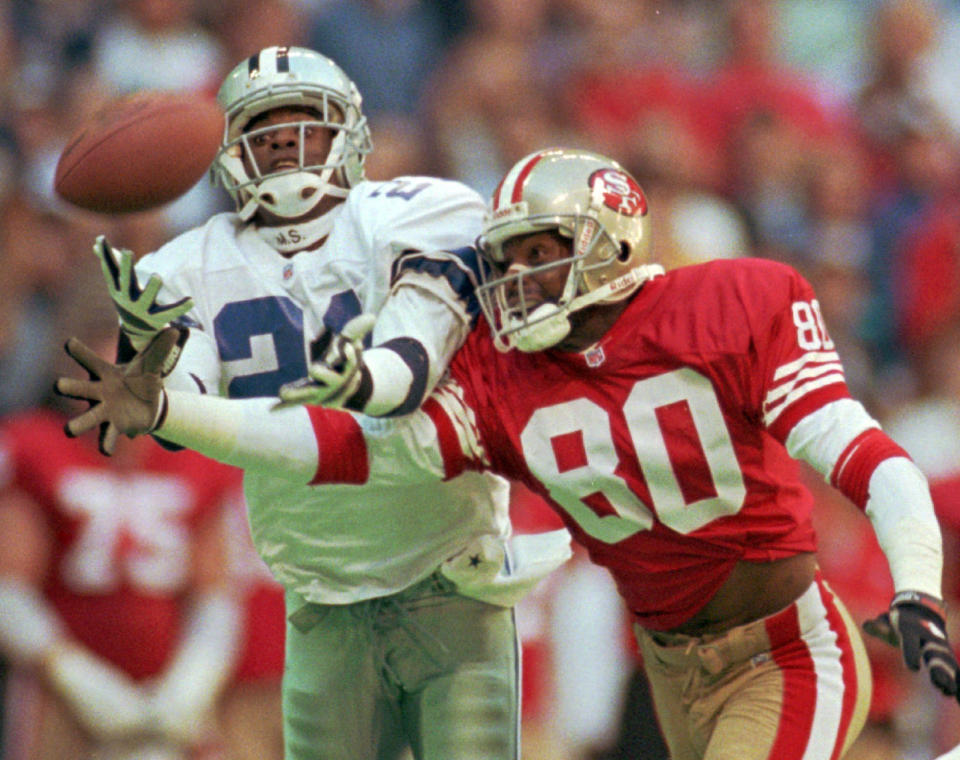 FILE - Dallas Cowboys defender Deion Sanders (21) knocks the ball away from San Francisco 49ers receiver Jerry Rice (80) in the second quarter of an NFL football game in Irving, Texas, Nov. 12, 1995. The 49ers-Cowboys playoff history is a rich one from back-to-back conference title games in the early 1970s, the iconic “Catch” in the 1981 season and then the heated rivalry in the 1990s when the Cowboys won the first two meetings on the way to Super Bowl titles and then the Niners took the third game. (AP Photo/Eric Gay, File)