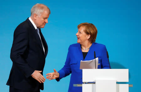 FILE PHOTO - Acting German Chancellor Angela Merkel and leader of the Christian Social Union in Bavaria (CSU) Horst Seehofer shake hands during a news conference after exploratory talks about forming a new coalition government at the SPD headquarters in Berlin, Germany, January 12, 2018. REUTERS/Hannibal Hanschke