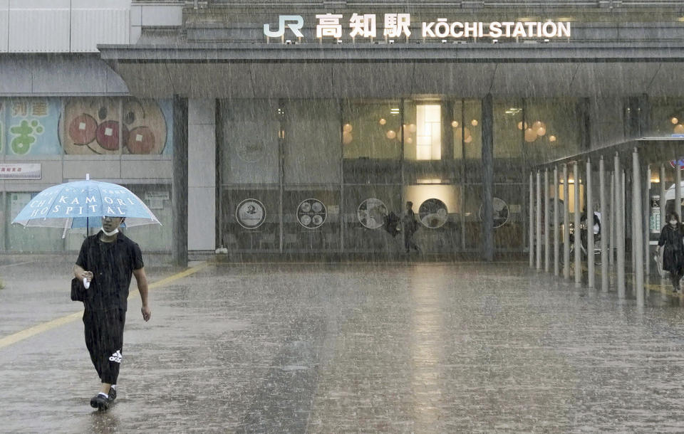 A person walks in a strong rain in Kochi, southern Japan Friday, June 2, 2023. A weakened Tropical Storm Mawar brought heavy rains to Japan’s main southern islands Friday after passing the Okinawan archipelago and causing injuries to several people. (Kyodo News via AP)