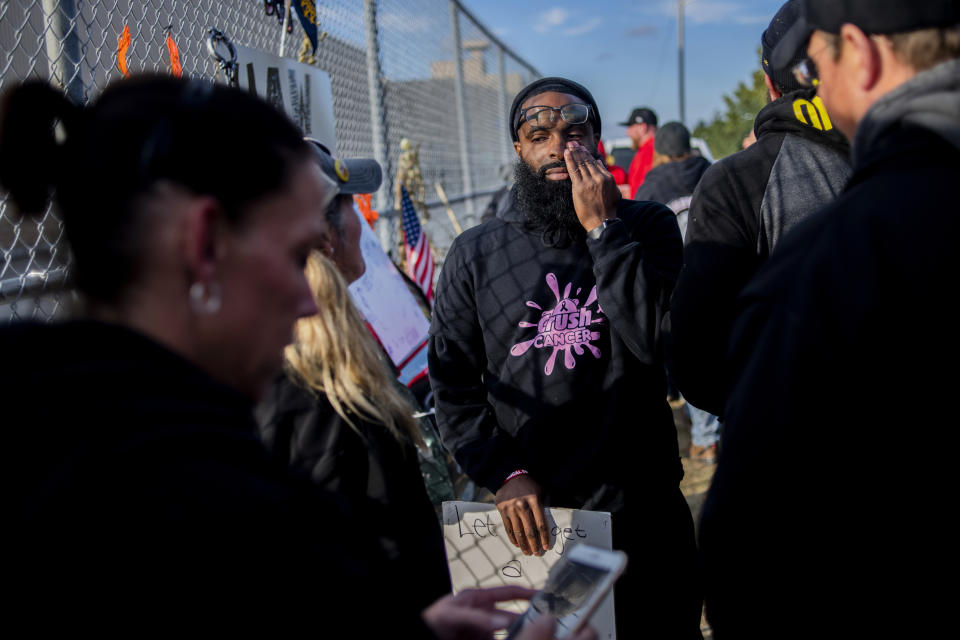 Alternate Committee Rep. Stanley Dulaney, Jr., 34, of Flint, and a 13-year employee at the Flint Assembly Plant, wipes away tears as he is emotionally overcome as the United Auto Workers strike against General Motors comes to a close outside of the Flint Assembly Plant, Friday, Oct. 25, 2019, in Flint, Mich. Striking General Motors factory workers are putting down their picket signs after approving a new contract that will end a 40-day strike that paralyzed the company's U.S. production. (Jake May/MLive.com/The Flint Journal via AP)