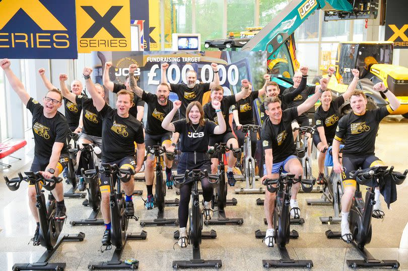 Hannah Roberts (centre) pictured with Lord Coe (second from right), George Bamford (second from left) and members of the JCB Around The World in 80 Days cycling team. -Credit:JCB