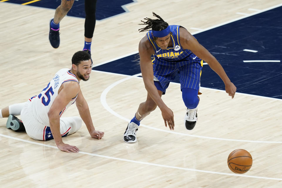 Philadelphia 76ers' Ben Simmons (25) and Indiana Pacers' Myles Turner (33) eye a loose ball during the first half of an NBA basketball game, Sunday, Jan. 31, 2021, in Indianapolis. (AP Photo/Darron Cummings)