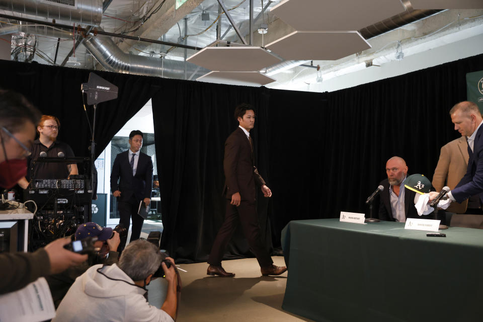 Oakland Athletics pitcher Shintaro Fujinami, center right, enters his introductory baseball news conference in Oakland, Calif., Tuesday, Jan. 17, 2023. (AP Photo/Jed Jacobsohn)