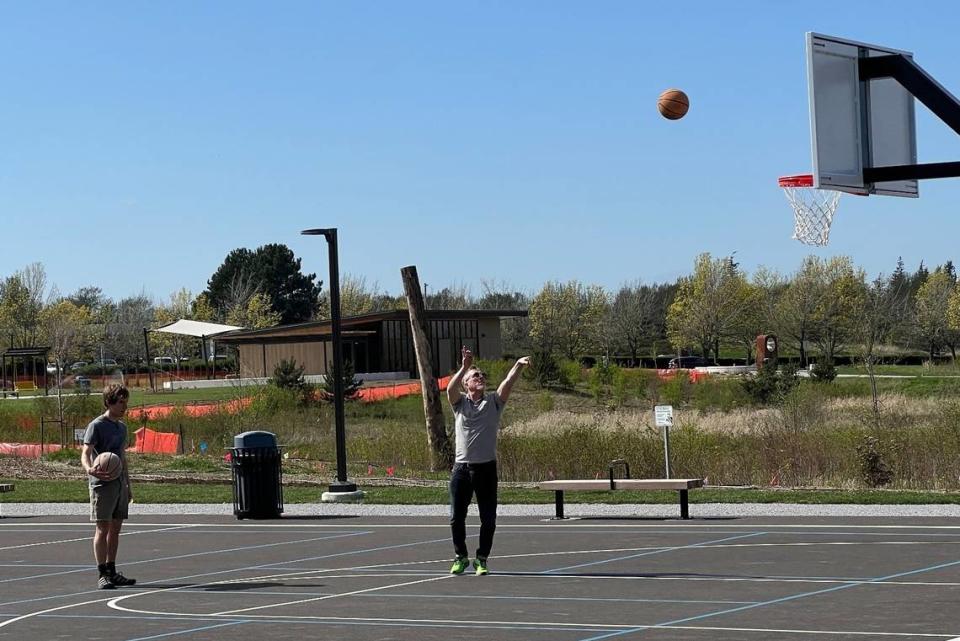 Erik Bracht takes a shot as he plays basketball with his son Forest on the new court at Cordata Park on Friday.