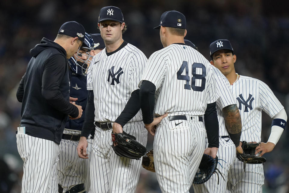New York Yankees starting pitcher Gerrit Cole, center, leaves the game as he is relieved by manager Aaron Boone, left, during the sixth inning of Game 3 of an American League Championship baseball series, Saturday, Oct. 22, 2022, in New York. (AP Photo/John Minchillo)
