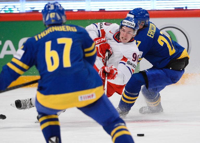 Czech hockey player Tomas Hertl (C) and Sweden's Jimmie Ericsson (R) fight for the puck during a match at the 2013 IIHF Ice Hockey World Championships in Stockholm, on May 4, 2013