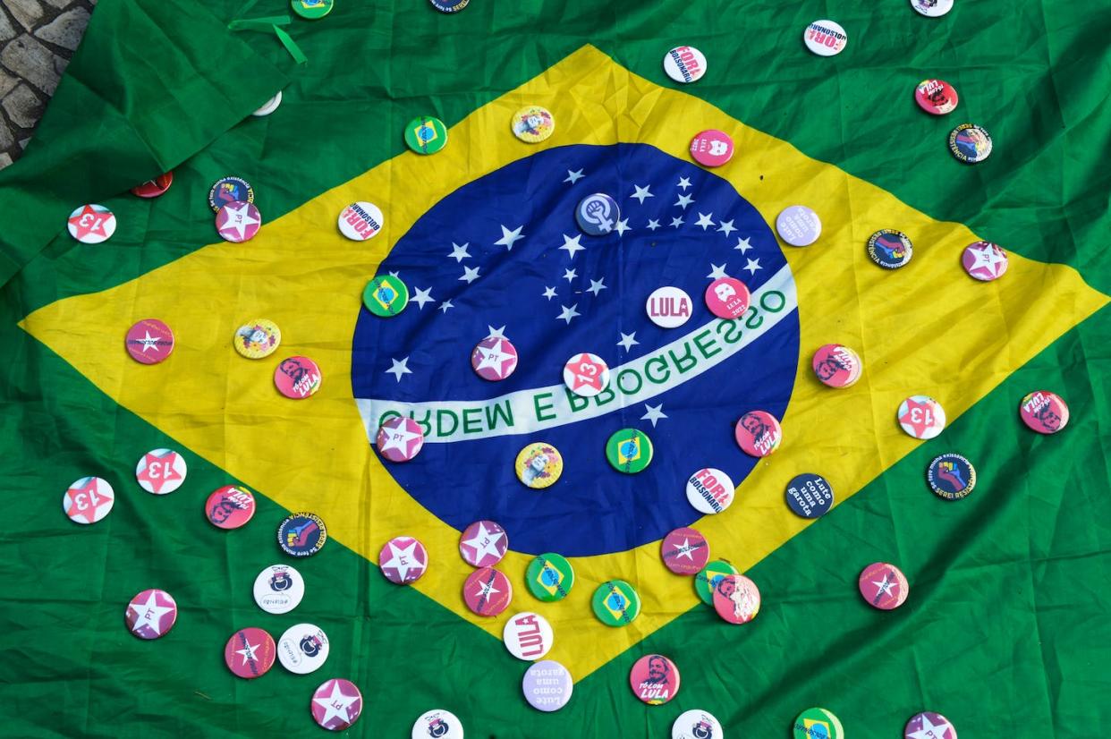 Chapas de apoyo a Lula sobre una bandera de Brasil. <a href="https://www.shutterstock.com/es/image-photo/rio-de-janeiro-brazil-july-24-2013826607" rel="nofollow noopener" target="_blank" data-ylk="slk:Shutterstock / Antonio Scorza;elm:context_link;itc:0;sec:content-canvas" class="link ">Shutterstock / Antonio Scorza</a>