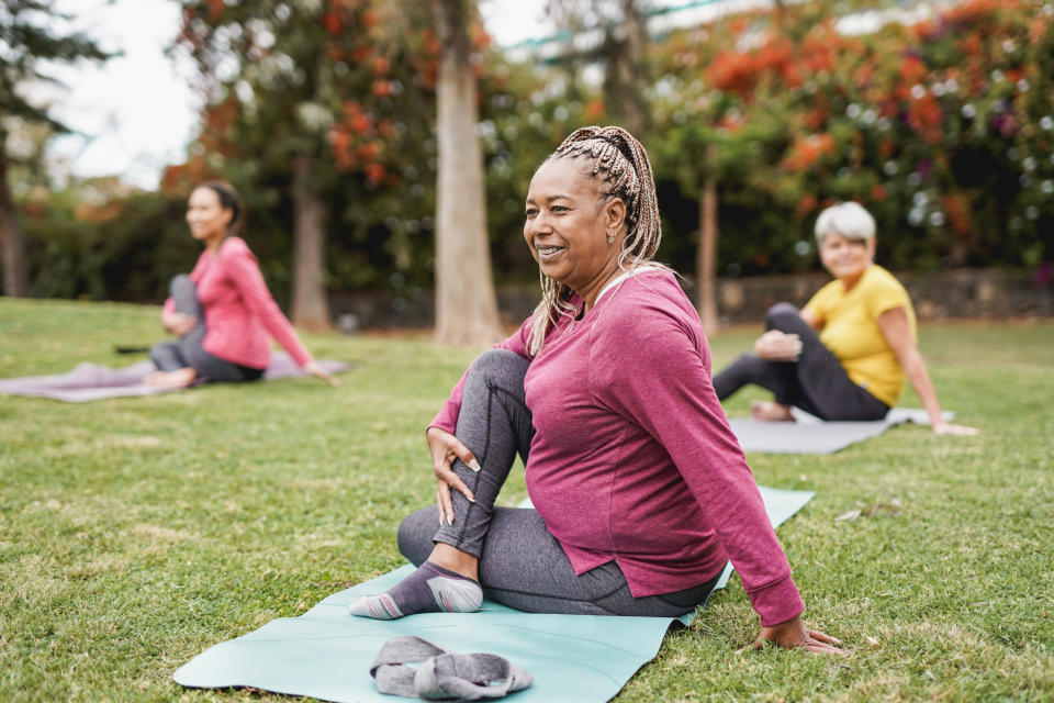 Women doing yoga exercises in a park.