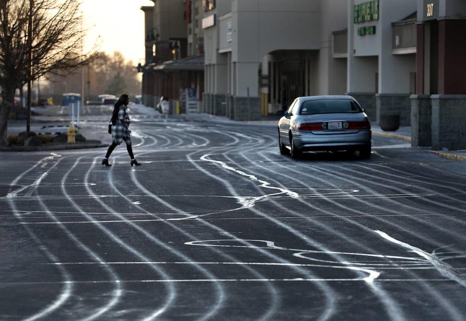 Fresh ribbons of recently applied liquid de-icer are visible Tuesday in the parking lot of the Kennewick Plaza shopping center off Highway 395. A winter weather advisory issued by the National Weather Service predicts wintry mix of snow and freezing rain for the Mid-Columbia through Wednesday night.