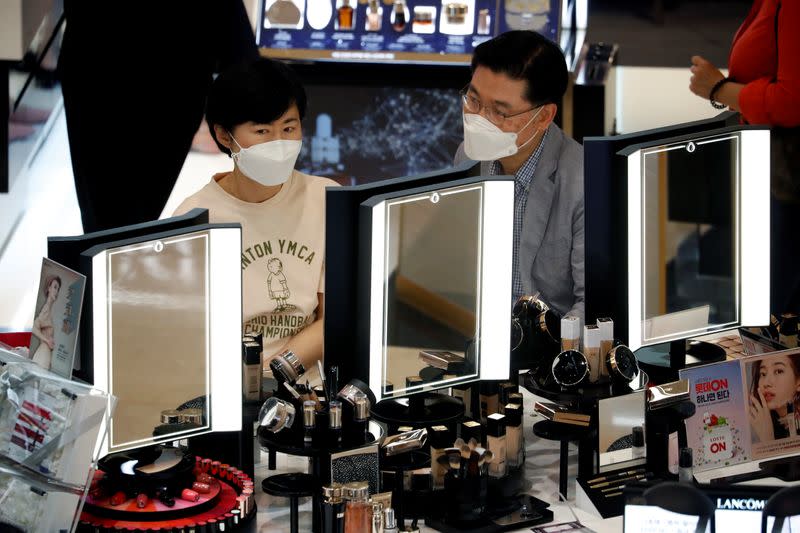A couple wearing masks to avoid the spread of the coronavirus disease (COVID-19) shop at a department store in Seoul