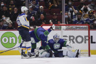 St. Louis Blues' Brayden Schenn, left, celebrates his goal against Vancouver Canucks goalie Michael DiPietro, right, as Tucker Poolman falls during the second period of an NHL hockey game in Vancouver, British Columbia, Sunday, Jan. 23, 2022. (Darryl Dyck/The Canadian Press via AP)