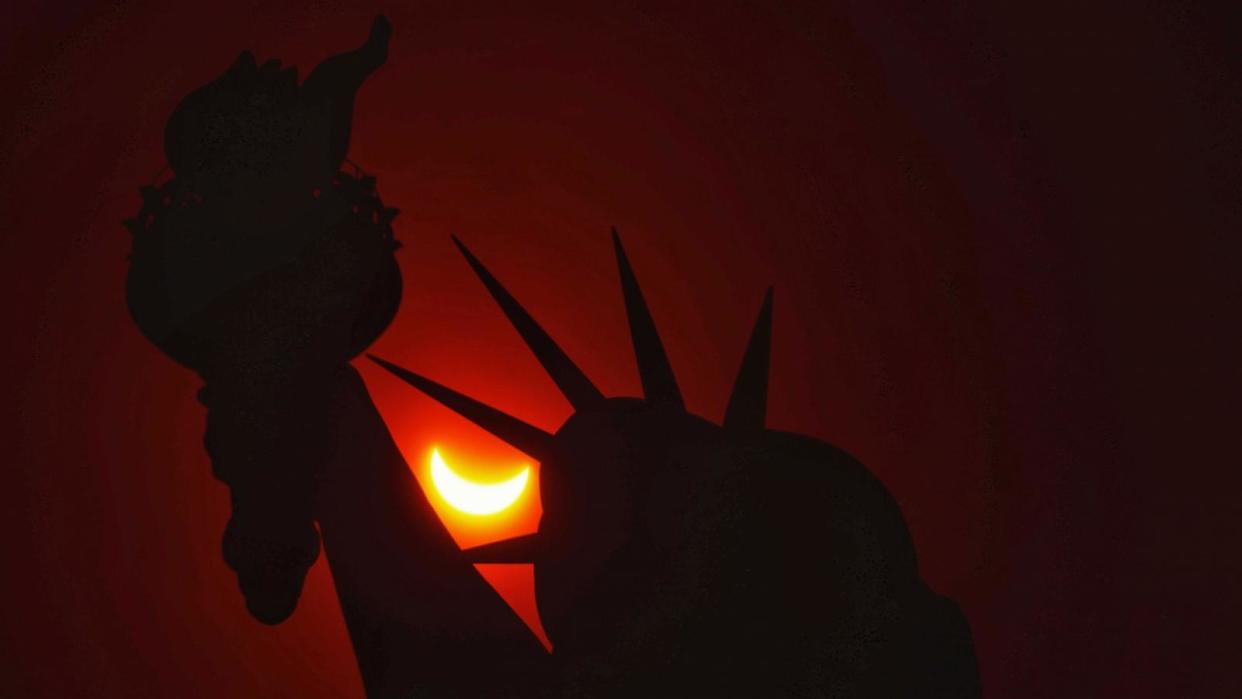 PHOTO: A partial eclipse shines through the Statue of Liberty, New York, April 8, 2024.  (Gary Hershorn/ABC News)