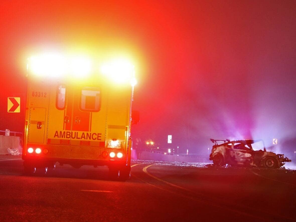 A car involved in a two-vehicle crash sits on the Sea-to-Sky Highway on Tuesday night after it appears to have caught fire. (Shane MacKichan - image credit)