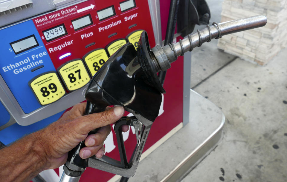 FILE - In this June 26, 2019, file photo, a man adds fuel to his vehicle at a gas station in Orlando, Fla. A coalition of states is suing the Trump administration for the second time to block a planned reduction in penalties automakers pay when they fail to meet fuel economy standards. Twelve states and the District of Columbia sued the administration Friday, Aug. 2, 2019, for replacing an Obama-era regulation that imposed a penalty of $14 for every tenth of a mile-per-gallon that an automaker falls below the standards. (AP Photo/John Raoux, File)