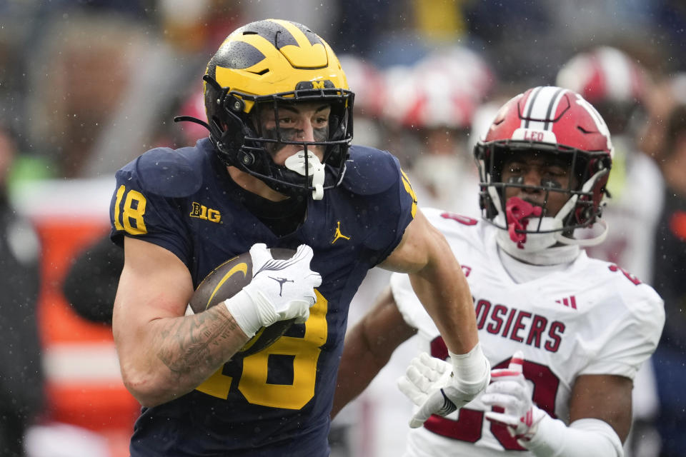 Michigan tight end Colston Loveland (18) catches a 54-yard touchdown reception as Indiana defensive back Louis Moore (20) defends in the second half of an NCAA college football game in Ann Arbor, Mich., Saturday, Oct. 14, 2023. (AP Photo/Paul Sancya)