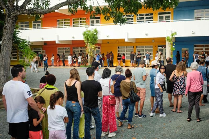 People queue outside a polling station in the Magenta district before casting their vote during the first round of the French parliamentary elections in Noumea, the first electoral district of the French Pacific territory of New Caledonia. Theo Rouby/AFP/dpa