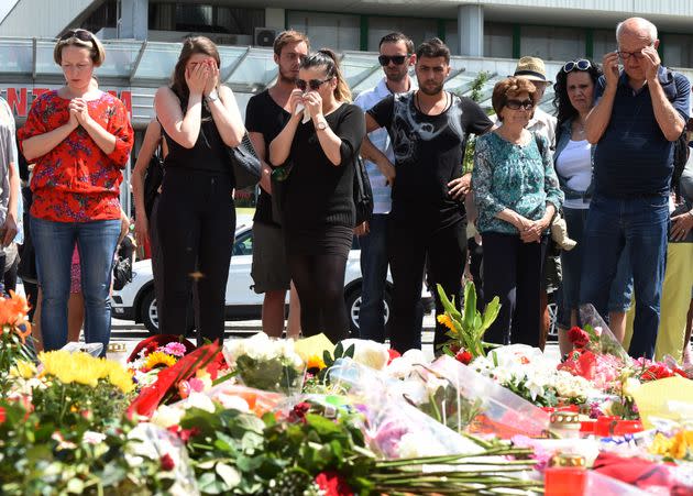 People mourn at a memorial of candles and flowers on July 24, 2016 in front of the Olympia Einkaufszentrum shopping centre in Munich (Photo: CHRISTOF STACHE via Getty Images)