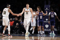 Denver Nuggets center Nikola Jokic (15) reacts with Aaron Gordon after being fouled during the second half of an NBA basketball game against the Brooklyn Nets, Wednesday, Jan. 26, 2022, in New York. The Nuggets won 124-118. (AP Photo/Adam Hunger)