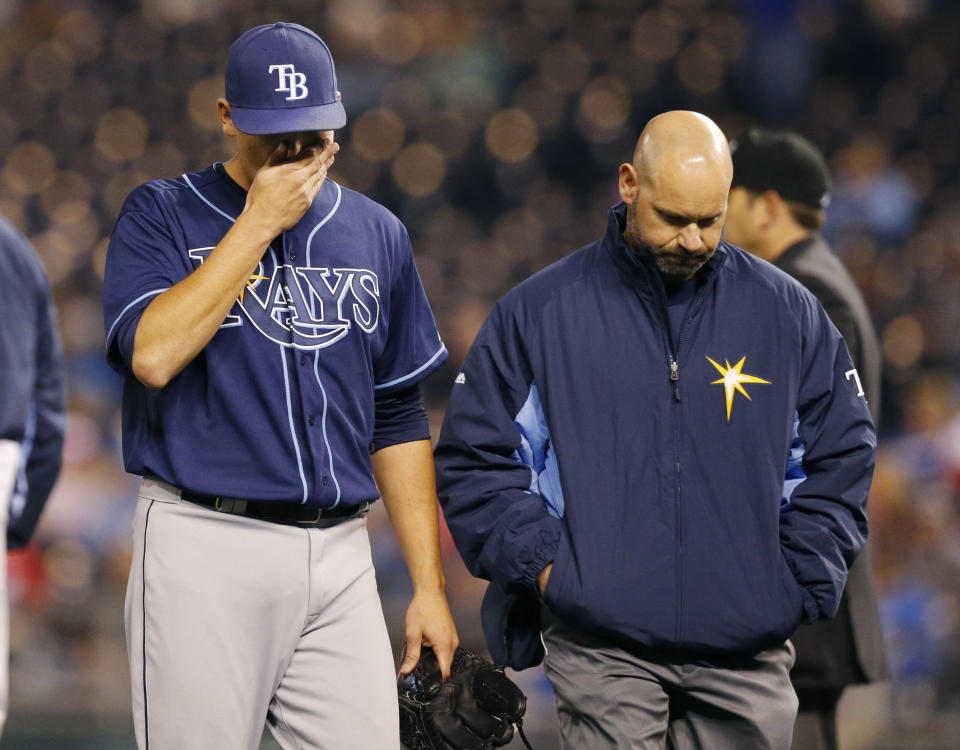 Tampa Bay Rays starting pitcher Matt Moore, left, walks off the field with a trainer following an injury during the sixth inning of the MLB American League baseball game against the Kansas City Royals at Kauffman Stadium in Kansas City, Mo., Monday, April 7, 2014. (AP Photo/Orlin Wagner)