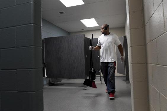 Lincoln cleans a bathroom at Amos House, where he works as a custodian for $11 an hour while training to be a ‘peer recovery coach’