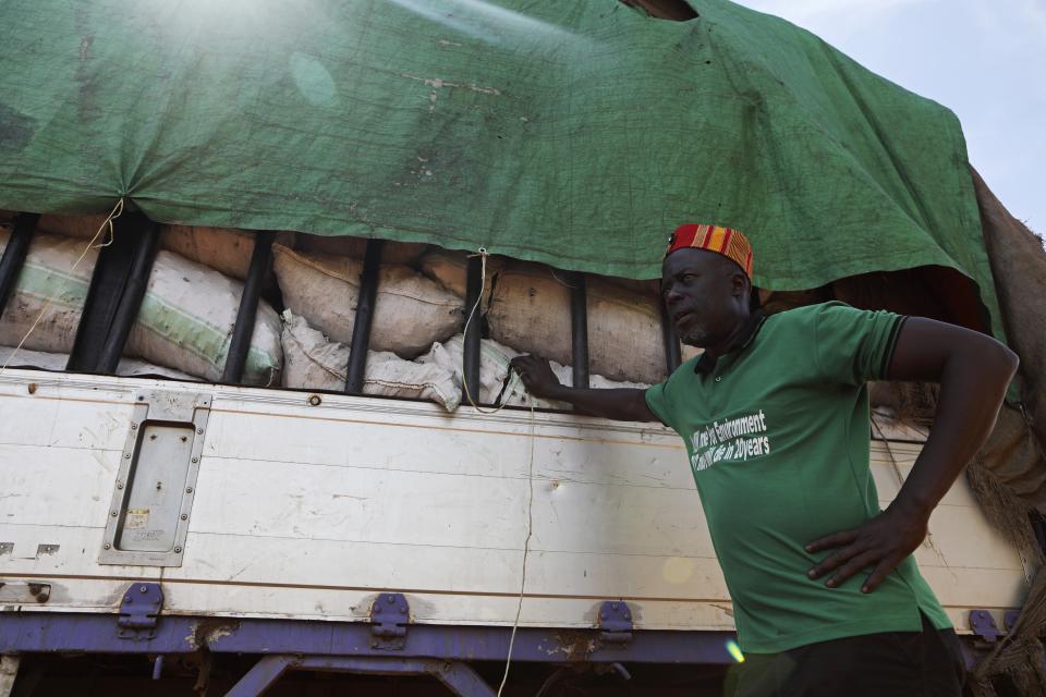 Odonga Otto stands near a truck carrying bags of charcoal in Gulu, Uganda, May 28 2023. Before the charcoal ban, local activists formed vigilante groups in districts such as Gulu, where Otto, a former lawmaker, led an attack on a truck that was dispossessed of about 380 bags of charcoal. Although Otto has since been charged with aggravated robbery, the country’s chief justice praised him as a hero. (AP Photo/Hajarah Nalwadda)