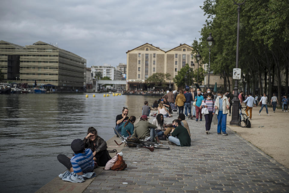 People relax by the Bassin de la Villette Canal, in Paris, France, Saturday, June 5, 2021. (AP Photo/Lewis Joly)