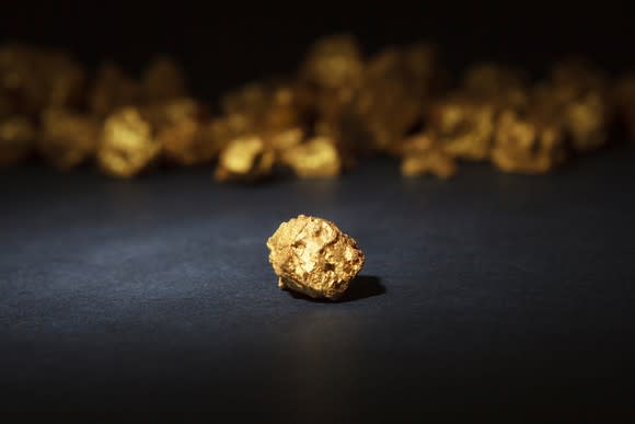 Gold nugget in focus with many nuggets in the background