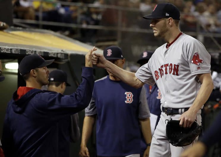 Boston Red Sox starting pitcher Chris Sale (right) is greeting at the dugout after recording his tenth and final strikeout against the A's. on Friday, May 19. (AP) 