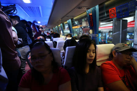 Janice Sarad, 22, who works for a bank, rides a crowded bus going to work in Cubao, Quezon City, Metro Manila, Philippines, November 26, 2018. REUTERS/Eloisa Lopez