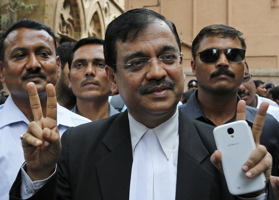 Public Prosecutor Ujjwal Nikam displays the victory symbol as he comes out of a court in Mumbai, India, Friday, April 4, 2014. The Indian court on Friday sentenced to death three men who raped a photojournalist inside an abandoned textile mill in the financial hub of Mumbai last year. A fourth defendant was sentenced to life in prison, Nikam said. (AP Photo/Rajanish Kakade)